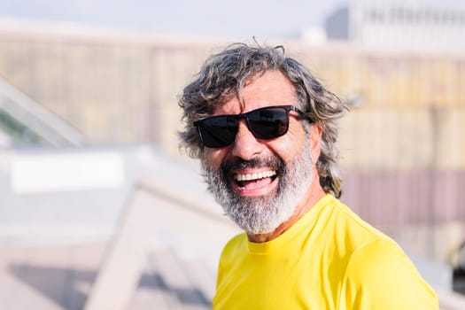 portrait of a senior man with sun glasses smiling happy looking at camera, copy space for text