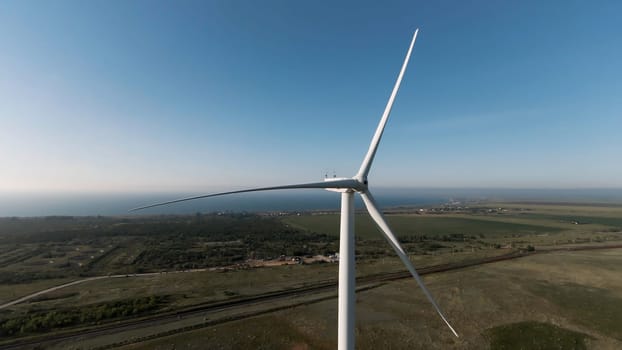 Scenic aerial view of wind turbines farm in daytime. Shot. Beautiful windmills, blue cloudy sky and farm fields