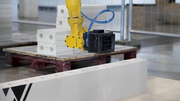 Industrial robot exhibit at work. Bricklayer robot for automated building construction, concept of robotic technologies in construction industry.