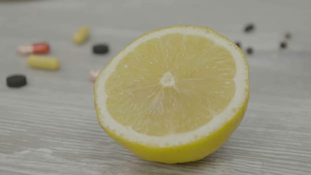 One half of a ripe yellow lemon on the table. One sliced lemon is on the table.