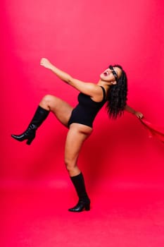 Sensual beautiful african ethnic woman in bodysuit posing in studio isolated red white background