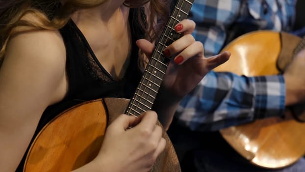 Woman playing music with balalaika. Lifestyle concept. Russian instrument. Folk music russian ensemble - woman playing the balalaika.