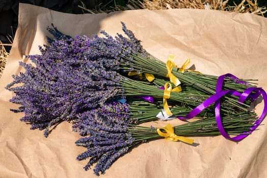Lavender bouquets with purple and yellow ribbons lie on kraft paper
