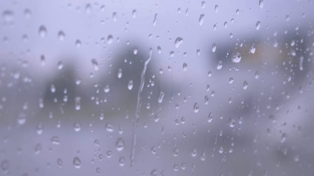 Glass wet, rain drops on the drenched window glass, autumnal rainy landscape blurred. Raindrops on the window from rain.
