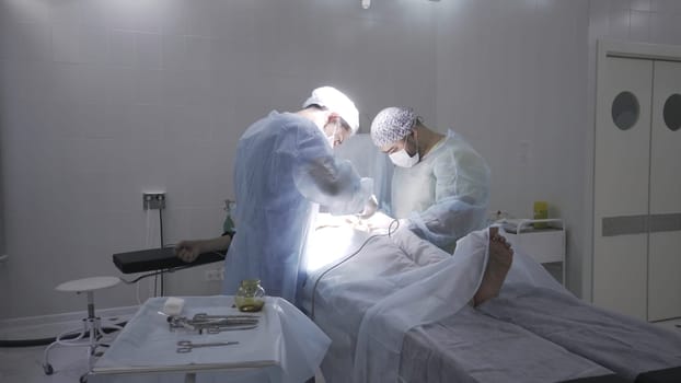 Two professoinal surgeons performing phimosis surgery. Male health concepts, medical procedure on male penis in sterile operating room.