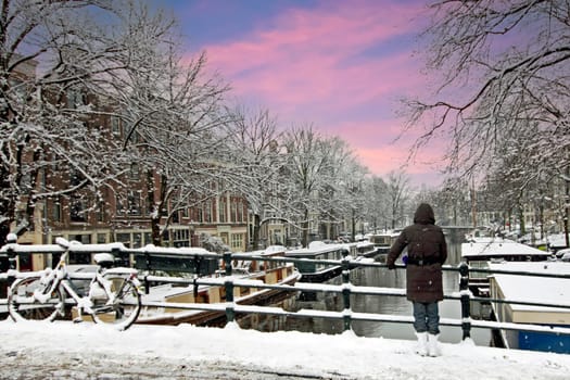 Amsterdam covered with snow  in winter in the Netherlands at sunset