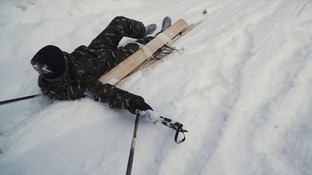 Skier after accident waiting for rescue lying in snow. Clip. Professional skier after crash accident on skiing resort slope - Winter sport emergency concept. Ski patrol team rescue injured skier with the special emergency sledges.