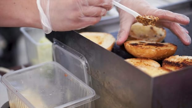 Potatoes prepare on a grill. Clip. Baking potatoes on the grill, the cook lubricates the potatoes with sauce. Hand Using Tongs For Turning potatoes on the Barbecue