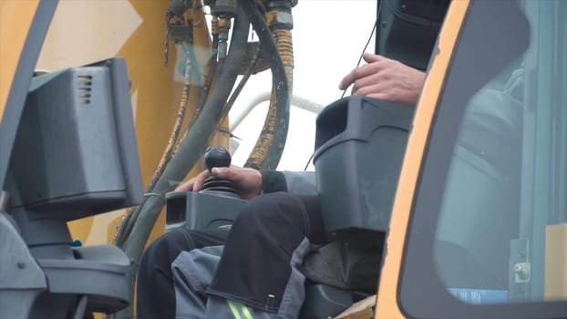 Engineer operator crane in action. Clip. Man in cabin controls the crane. He sit a top in crane cabin and working.