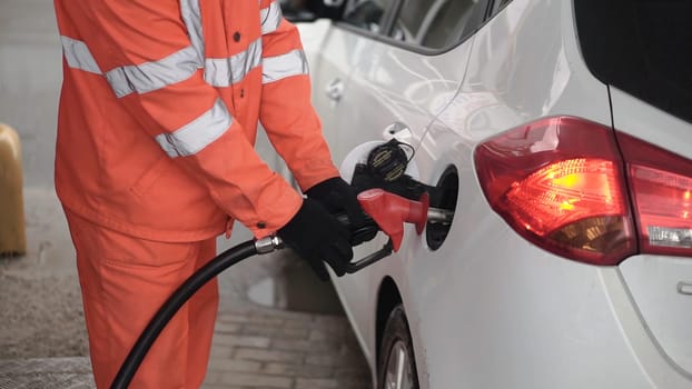 Gas Station Worker Refilling Car at Service Station. Clip. Male gas attendant fills the car.