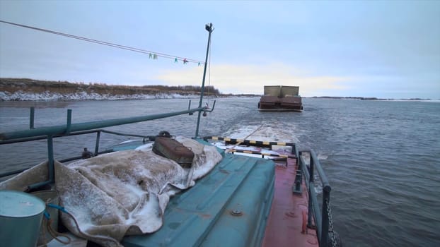 View from the ship on a barge trailer with goods. Clip. Concept of water transportation, containers on a barge and a wide river
