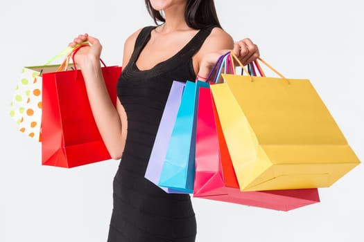 Happy shopping. Unrecognizable woman in black dress holding multicolored shopping bags