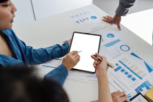 businesspeople using digital tablet and working on project together in meeting room.