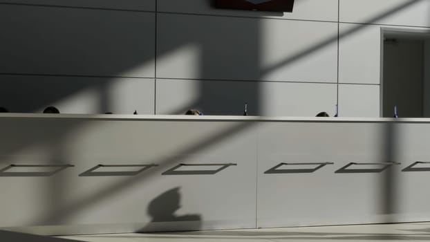 Minimalistic interior of a hotel lobby with the reception desk. HDR. Concept of architecture and design, grey reception desk and a wall with a minimum of details