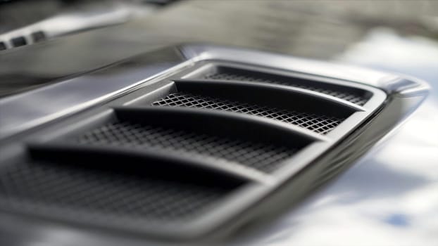 Close up for detail of air vents on the bonnet of a modern black car. Car exterior background detail of air intake in hood, design concept.