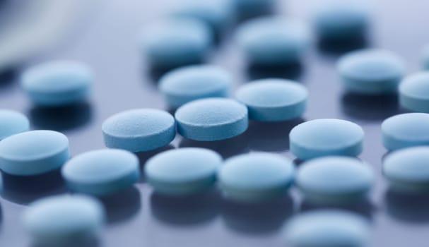 Tablets scattered blue color on the table of pharmaceutical laboratory pill for the prescription and treatment various diseases chemistry