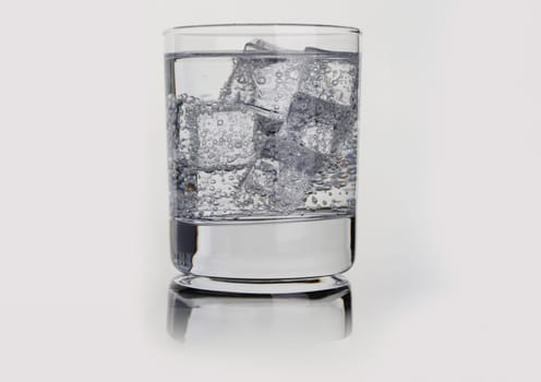 Closeup of glass with mineral water and ice. Quenching thirst concept