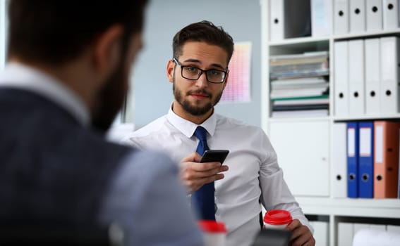 Businessman hold in arms paper cup of hot fresh coffee and cellphone at office workplace portrait. Read news mania send sms chat addict use electronic bank modern idea job share blog tweet web search
