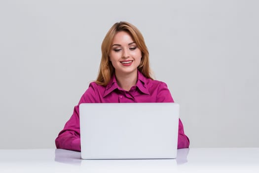 Young businesswoman working at laptop computer. she smiles, prints and looking at monitor