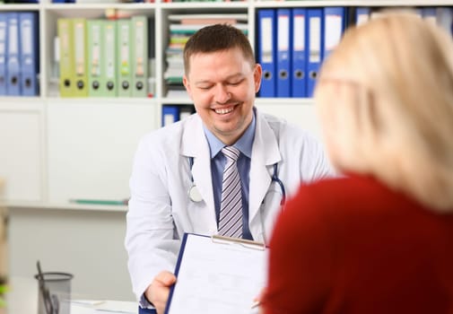 Handsome smiling male doctor talk with patient about his history list. Physical exam er anamnesis communication disease prevention ward round 911 prescribe remedy healthy lifestyle concept