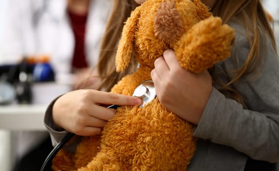 Female hand of little girl hold stethoscope listen heart bit concept closeup