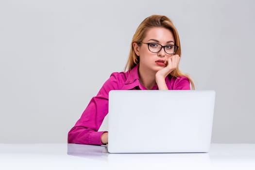 Young businesswoman working at laptop computer. she was tired and looking at camera