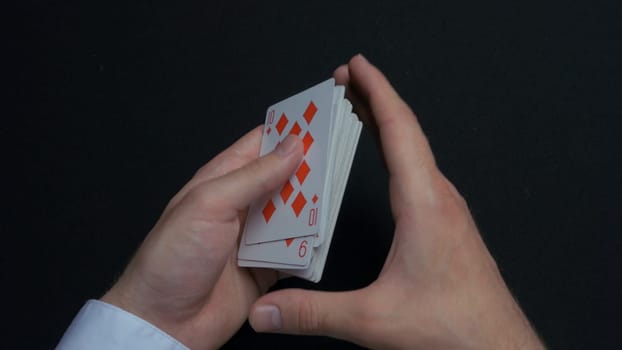 Poker game - shuffling cards. Man's hands shuffing cards. Close up. Man's hands shuffling playing cards. Dealer's hands shuffling cards during a poker game 4K