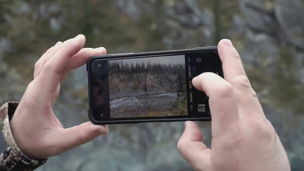 Tourists take photos of the participants of the hike in the forest on their phone. CLIP. A family poses for a photographer during their journey.