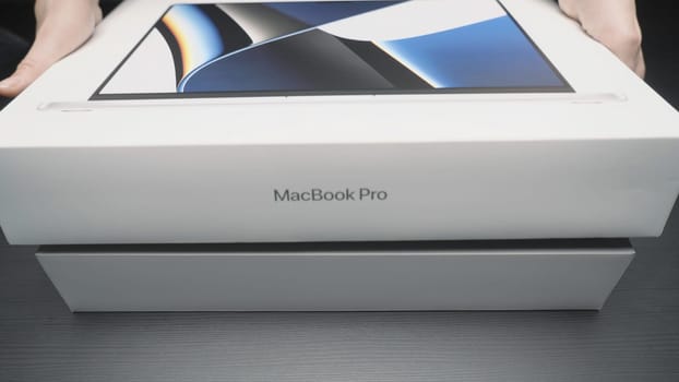 China, Beijing - April 22, 2023: Close-up of new laptop model. Action. Unpacking new MacBook model from Apple. New laptop from Apple for professional design work.