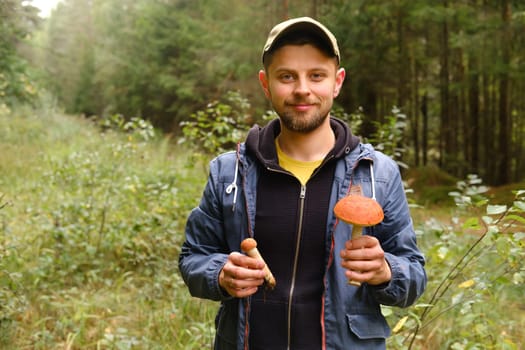 A mushroom picker holds in his hands an aspen bush growing in the forest. Mushrooms in the forest. Mushroom picking.