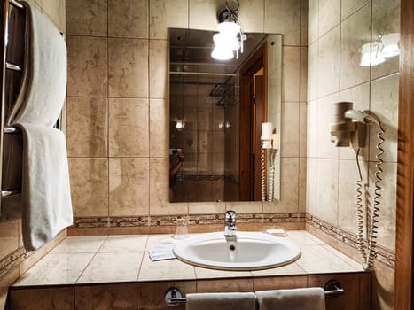 Perm, Russia - July 04, 2023: Modern bathroom interior with stylish mirror, towel, vessel sink