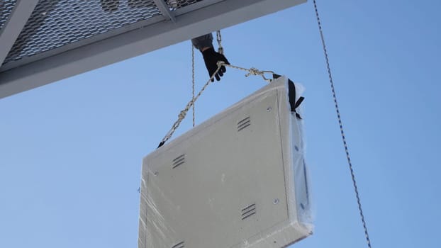 Men assemble Billboard on tap. Builder on a Lift Platform at a construction site. Man rises to the top part of the Billboard for advertising.