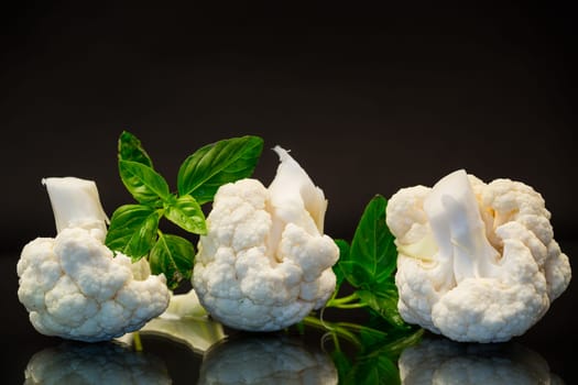 slices of raw small raw cauliflower isolated on black background