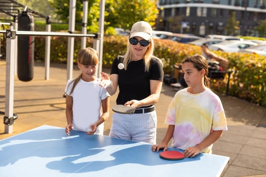 Cute girls playing ping-pong indoors. High quality photo