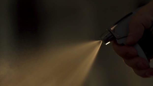 Close-up of barber splashes water on client's hair in slow motion. Frame. Hairdresser spraying water and combing wet hair. Male hairstyle in salon. Man hair styling. Close up of barber haircut. Barber styling hair in barbershop. Soft focus