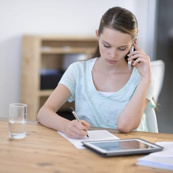 Creative, woman and phone call while writing notes with tablet in office for planning research, information and communication in agency. Designer talking on cellphone with documents and digital tech.