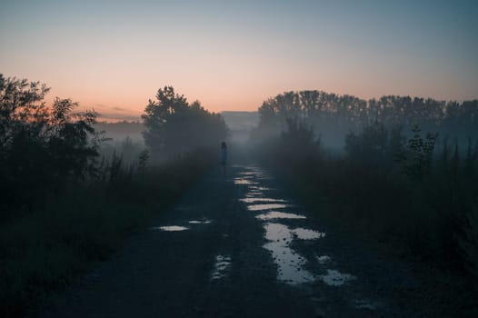 Woman in beautiful misty fog, summer landscape