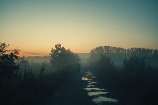 Woman in beautiful misty fog, summer landscape