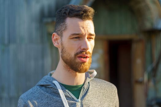 Stylish Man in a Grey Sweatshirt, portrait of a young millennial with a beard.