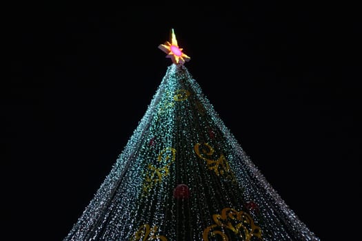 Festive Christmas Tree Illuminated with Twinkling Lights on a Black Background