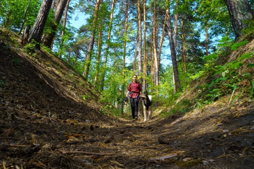 Girl walks with her beloved dog in the forest. Walking with pets