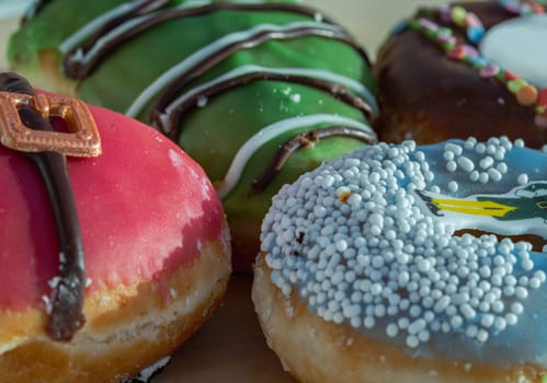 Close-up of Four glazed Doughnuts placed on wooden cutting board. The concept of delicious delicious amazing glazed donuts, Space for text, Selective Focus.
