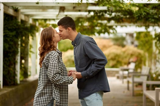 Young Cute Female Hugs Boyfriend. In Autumn Outdoor. Lovers Walking in Park. Attractive Funny Couple. Lovestory in Forest. Man and Woman. Cute Lovers in the Park. Family Concept. Happy Couple.