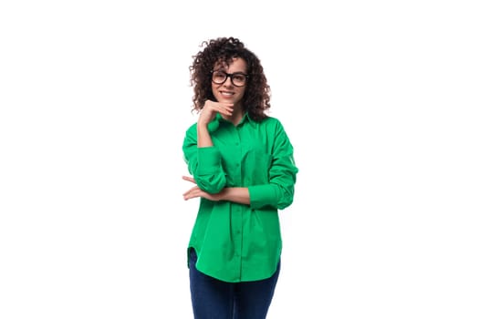 well-groomed young marketing employee woman in glasses dressed in a green blouse shows like.