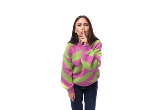 portrait of a young brunette woman in a striped pink green blouse on a white background with copy space.