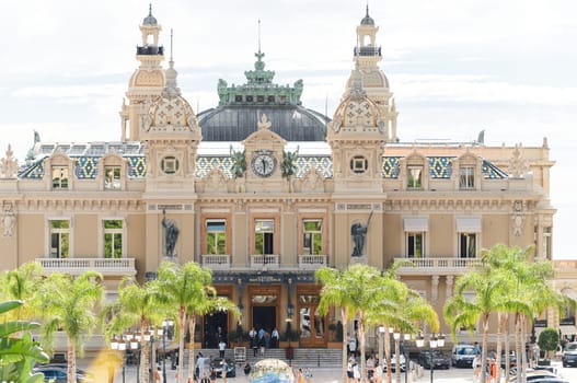 Monaco, Monte-Carlo, 21 October 2022 - Square Casino Monte-Carlo at sunny day, wealth life, tourists take pictures of the landmark, pine trees, blue sky. High quality photo