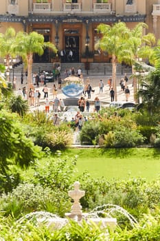 Monaco, Monte-Carlo, 21 October 2022 - Square Casino Monte-Carlo at sunny day, wealth life, tourists take pictures of the landmark, pine trees, blue sky. High quality photo