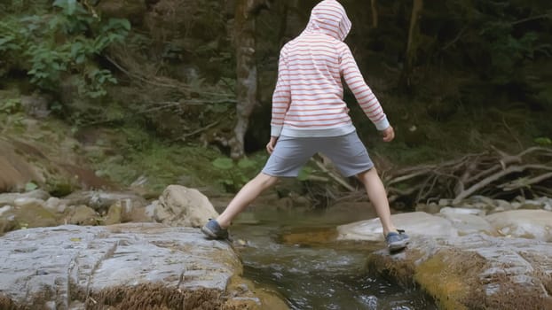 Boy walks in wild forest in summer. Creative. Boy enjoys and has fun walking in wild forest in summer. Summer hike with child in forest.