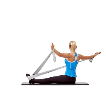 Sport, resistance band and woman doing exercise in studio for health, wellness and bodycare. Fitness, yoga mat and young female person from Australia with arms workout or training by white background.