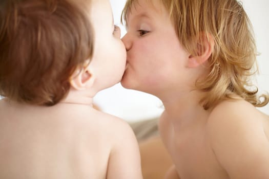 Family, love and baby siblings kissing closeup in their home for love, growth or child development. Kids, together or bonding with an infant child and his brother in a bedroom of their apartment.